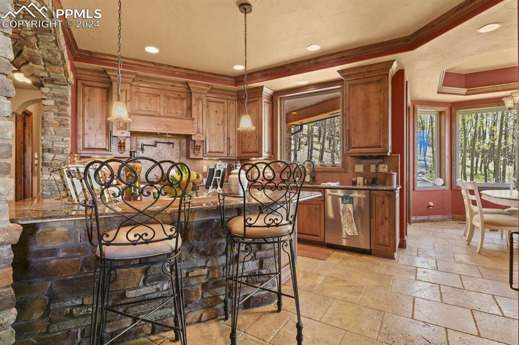 Image 11 of 50: Kitchen with a tray ceiling, crown molding, stainless steel dishwasher, pen
