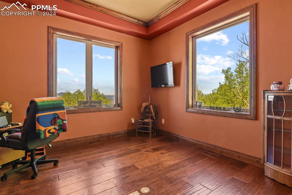 Image 16 of 50: Home office featuring dark hardwood / wood-style floors and crown molding