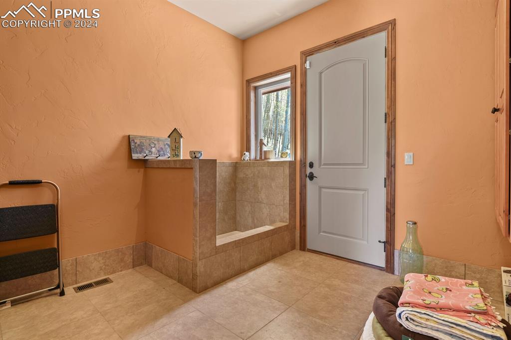 Image 18 of 50: Bathroom featuring tile flooring and a bath