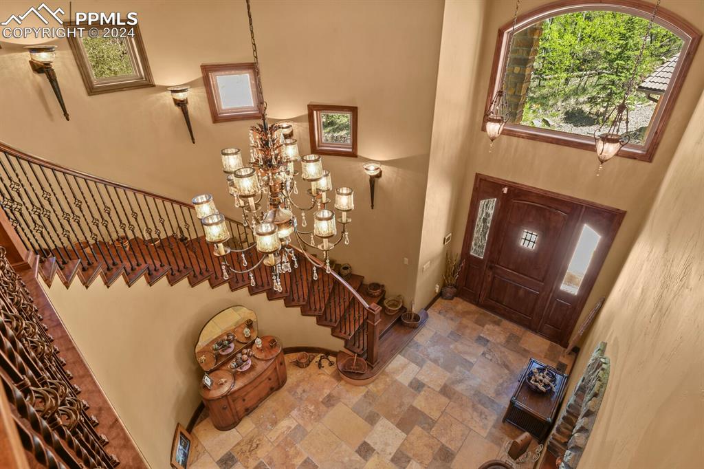 Image 19 of 50: Foyer with a high ceiling, a notable chandelier, and tile flooring