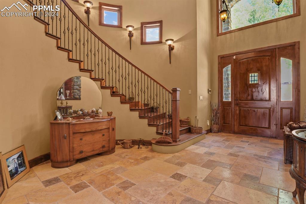 Image 2 of 50: Entrance foyer with a high ceiling and tile floors