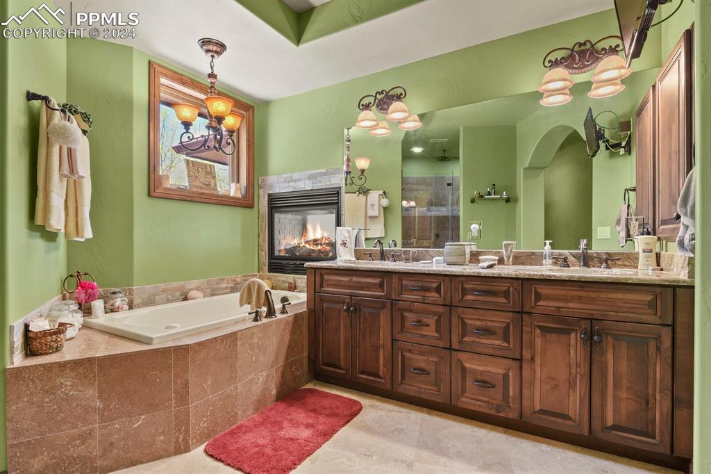 Image 22 of 50: Bathroom with dual vanity, an inviting chandelier, tile floors, a multi sid