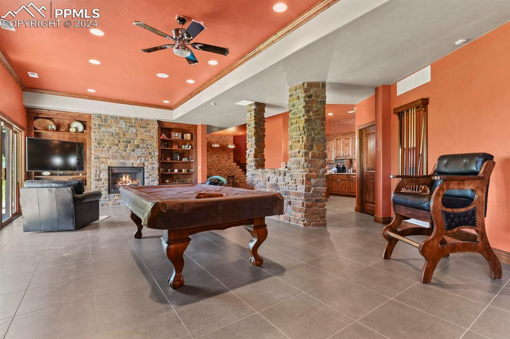 Image 29 of 50: Game room featuring tile floors, a fireplace, billiards, and built in featu