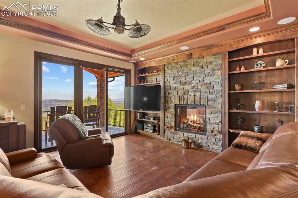 Image 4 of 50: Living room featuring crown molding, built in features, a fireplace, and ha