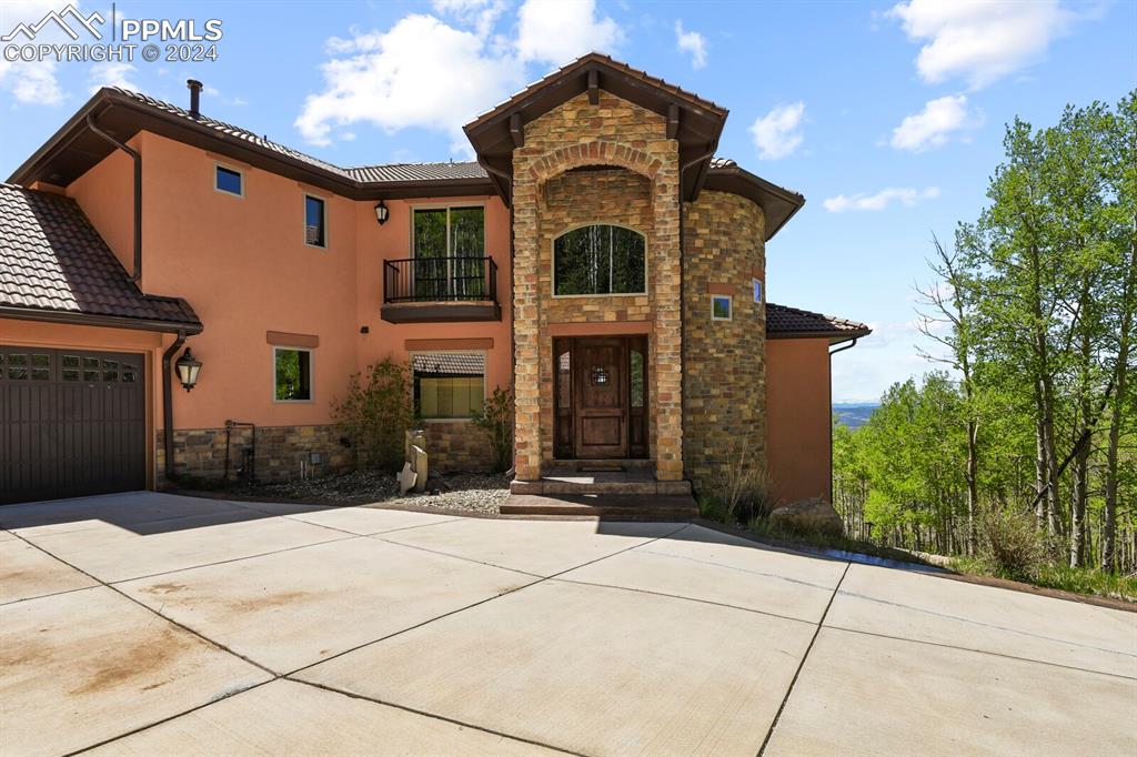 Image 43 of 50: View of front of home featuring a garage and a balcony