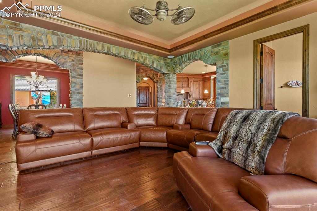Image 6 of 50: Living room featuring a notable chandelier, hardwood / wood-style flooring,