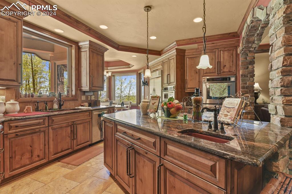 Image 9 of 50: Kitchen featuring stainless steel appliances, light tile flooring, hanging 