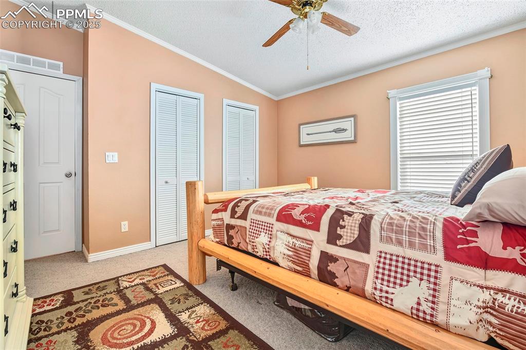 Image 23 of 29: Master Bedroom off Kitchen with Double Closet Doors and Large Windows with 