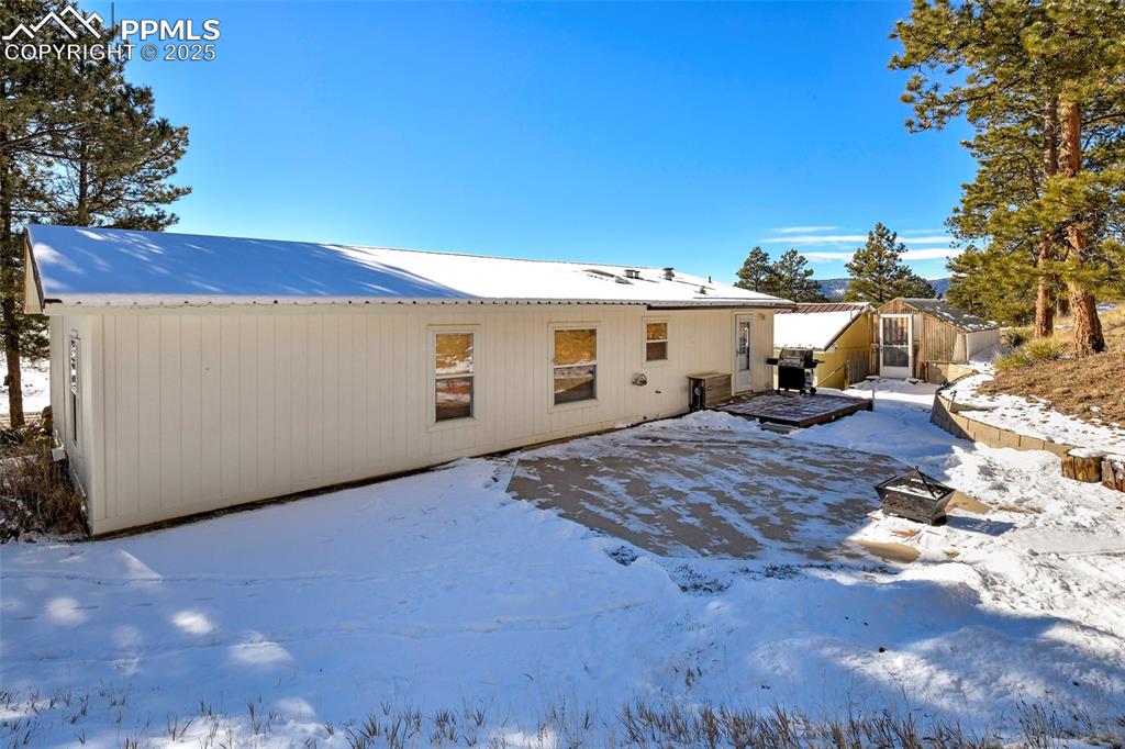 Image 9 of 29: Snow covered Back Yard with Greenhouse, Firepit and Decking for Family BBQs