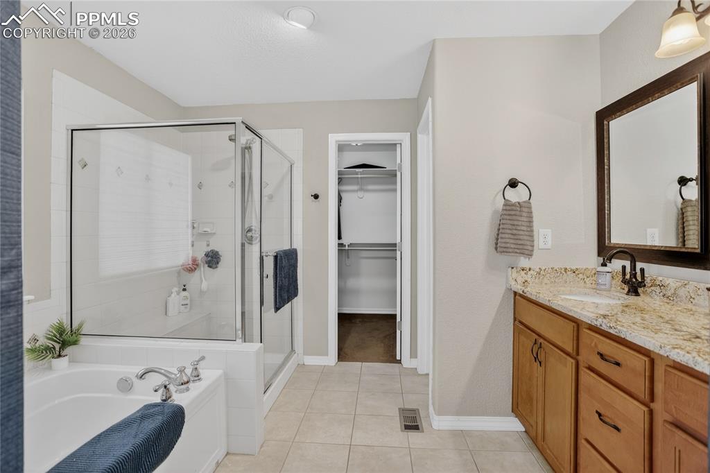 Image 12 of 25: Walk-in closet and large soaking tub