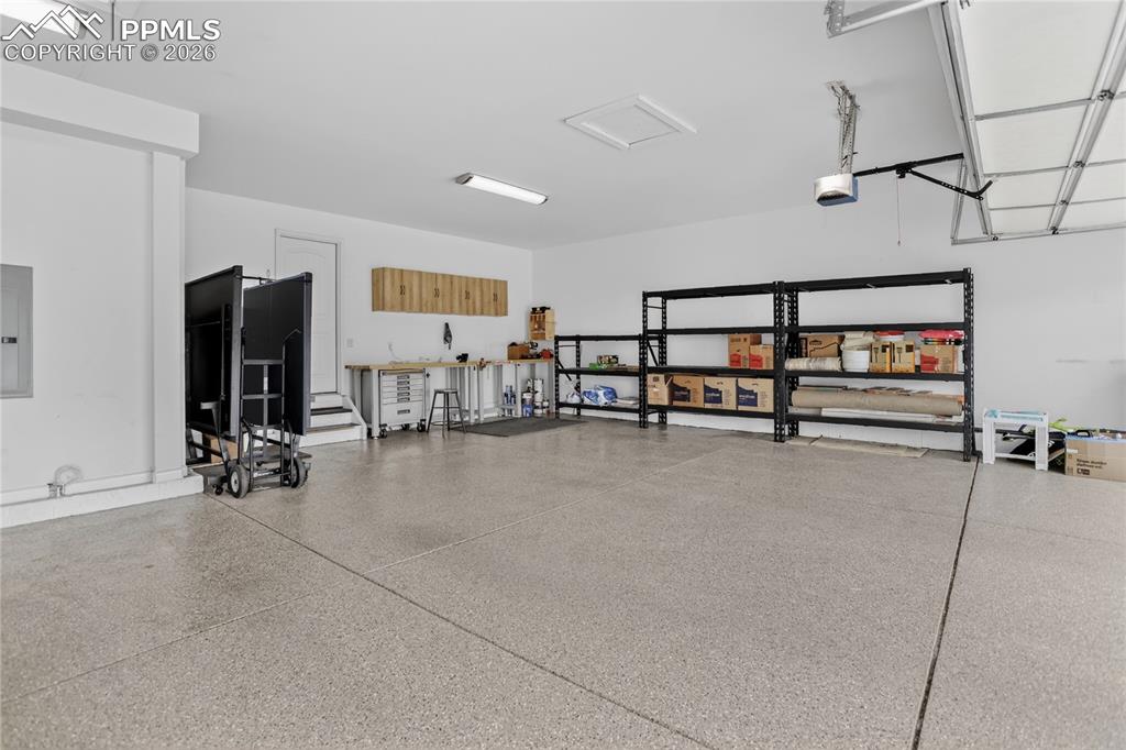 Image 22 of 25: Finished garage w/ epoxy flooring