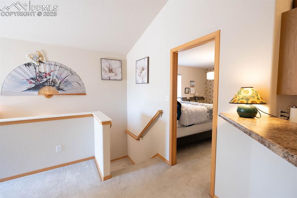 Image 13 of 37: Off the family room is a bedroom and the steps leading to the lower level.