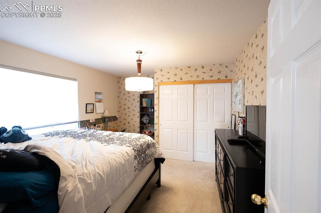 Image 21 of 37: secondary bedroom at the back of the home off the staircase.