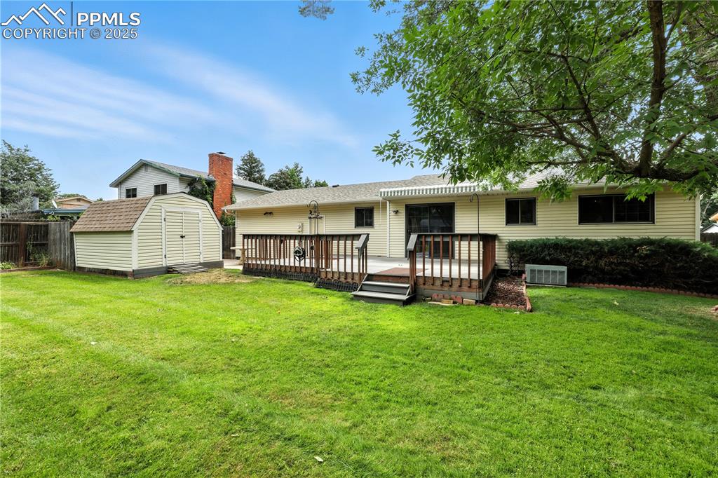 Image 11 of 50: Rear view of home with deck and patio for entertaining and large storage sh