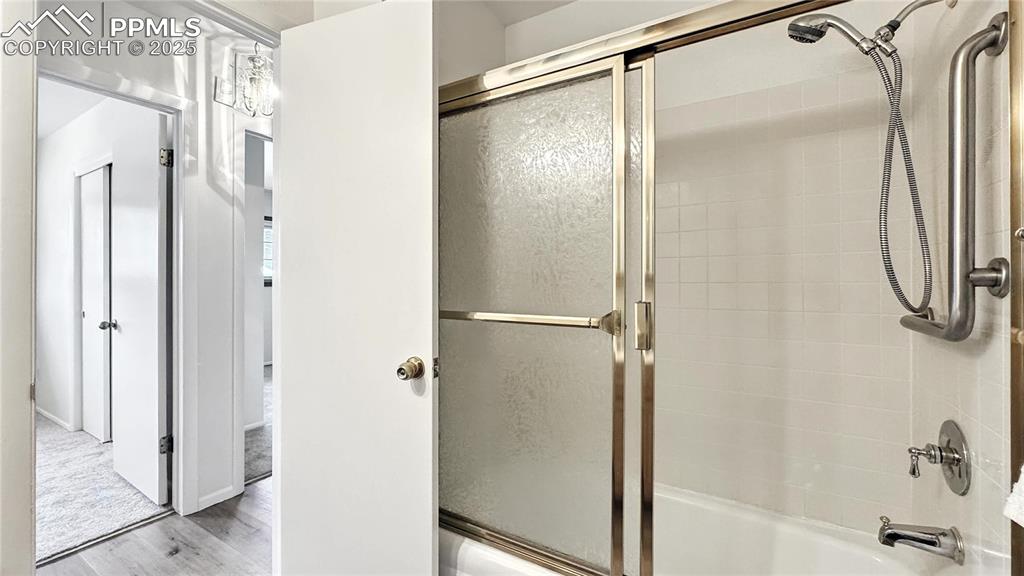 Image 22 of 50: Main level bathroom with an enclosed tub/shower combo
