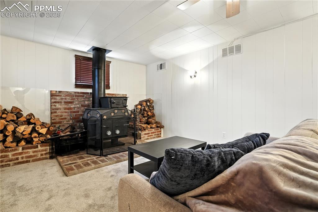 Image 30 of 50: Cozy wood-burning fireplace in the family room