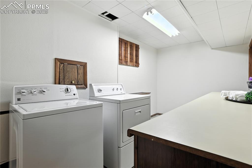 Image 36 of 50: Spacious basement laundry room with bright lighting