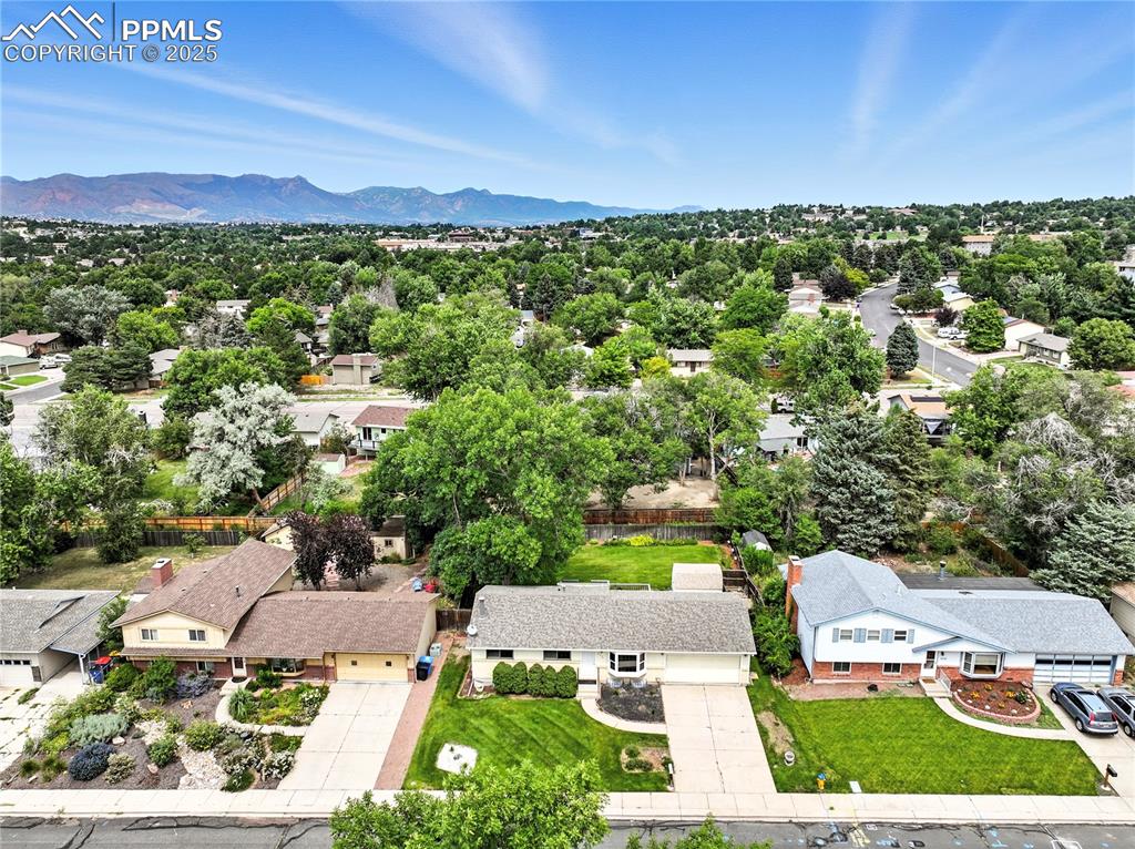 Image 46 of 50: Aerial view of residential area featuring a mountainous background