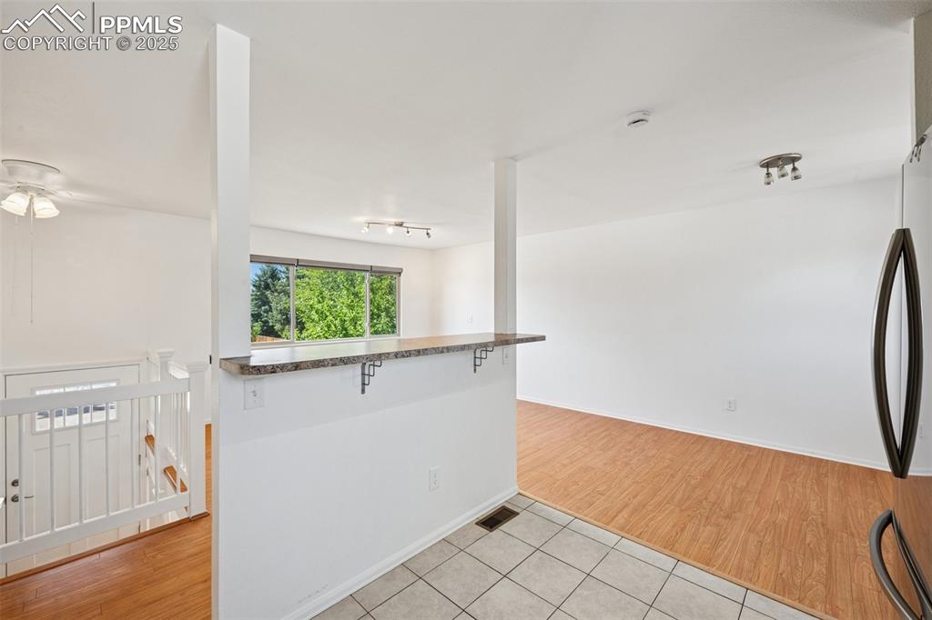 Image 10 of 35: Empty room with light tile patterned flooring and baseboards