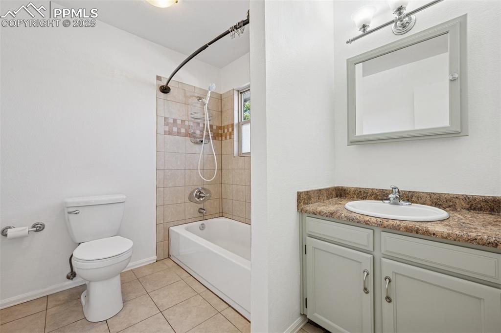Image 13 of 35: Bathroom with  shower combination, vanity, and light tile patterned floorin