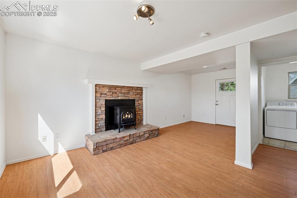 Image 18 of 35: Unfurnished living room featuring washer / dryer, light wood-style flooring