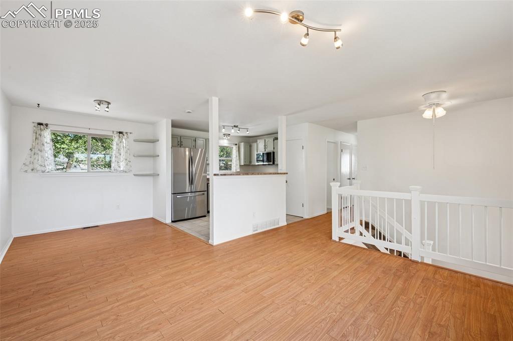 Image 8 of 35: Unfurnished living room with plenty of natural light, light wood-style floo