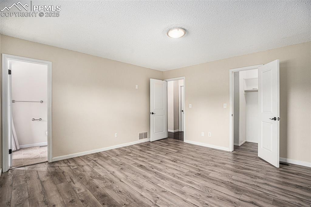 Image 13 of 31: Unfurnished bedroom featuring a textured ceiling and wood finished floors