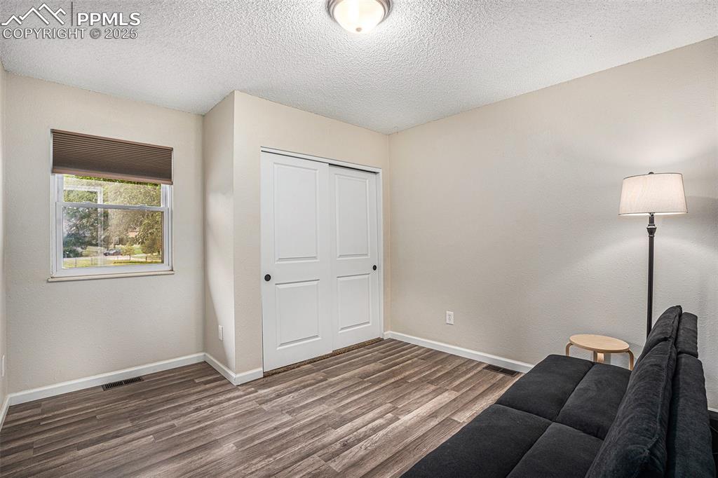 Image 16 of 31: Sitting room featuring a textured ceiling and wood finished floors