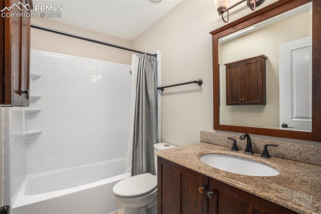 Image 17 of 31: Full bath featuring vanity, shower / bath combo, and a textured wall