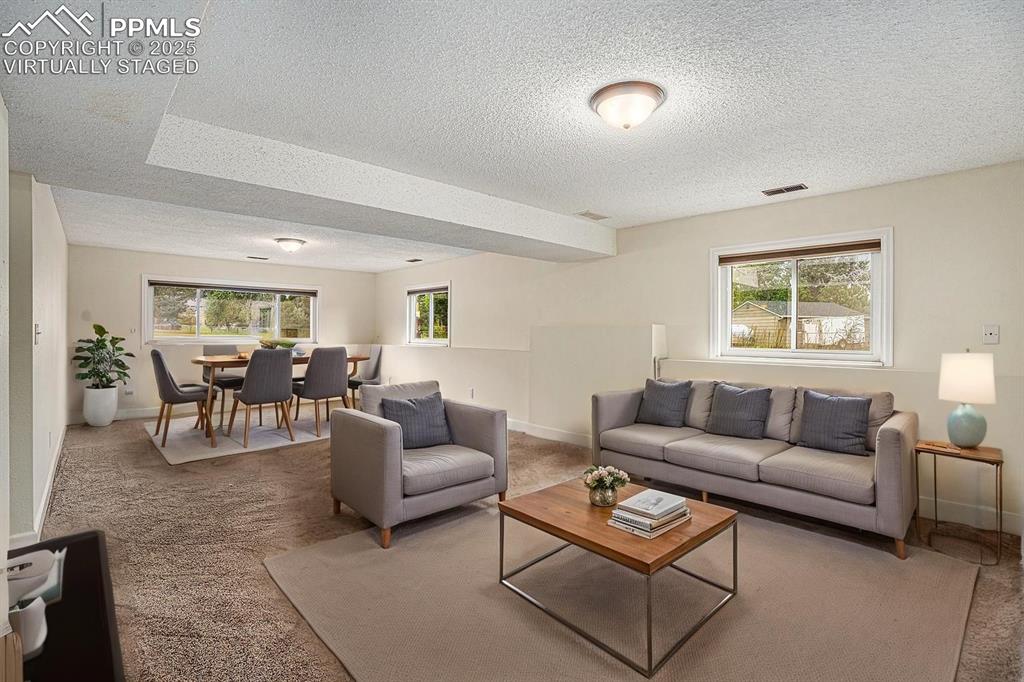 Image 19 of 31: Virtually Staged. Carpeted family room area with a textured ceiling and bas