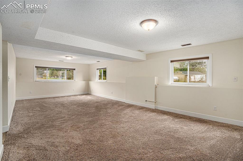 Image 20 of 31: Family room featuring light colored carpet and a textured ceiling