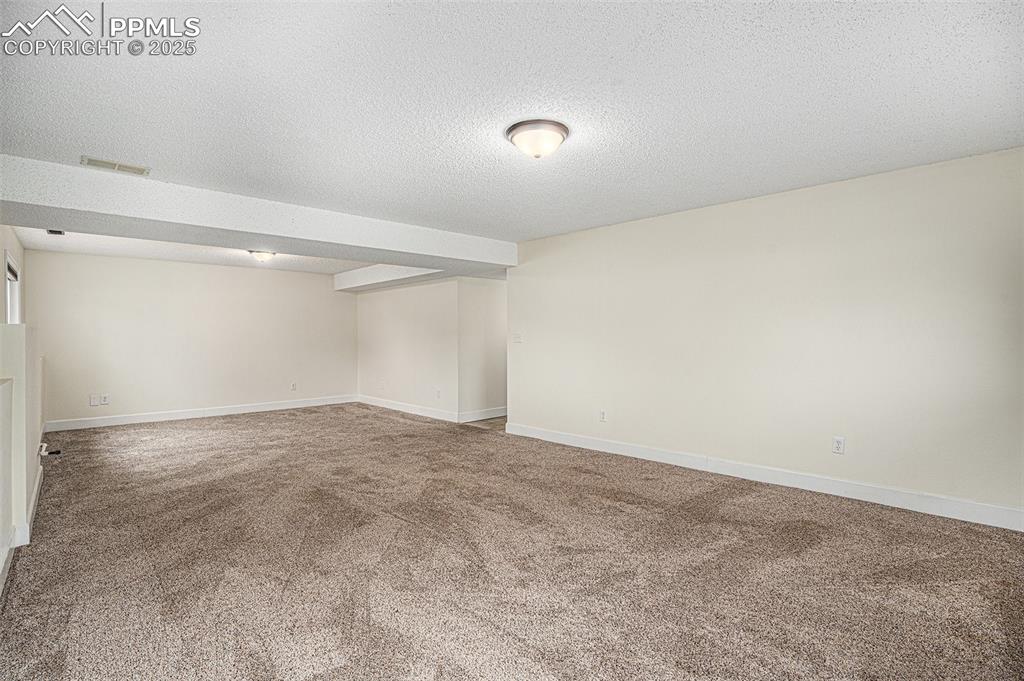 Image 22 of 31: Family room featuring a textured ceiling and carpet floors