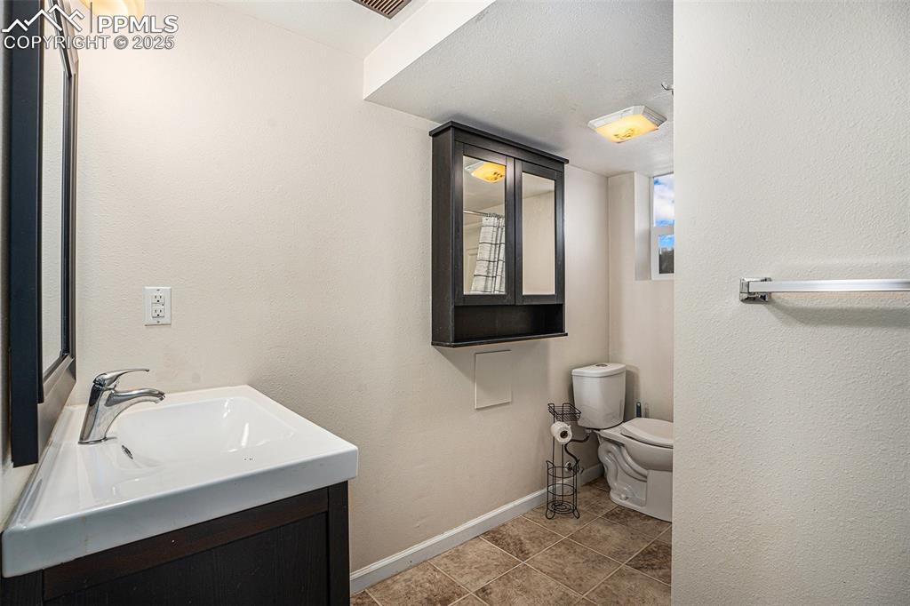 Image 23 of 31: Bathroom featuring vanity, tile patterned floors, and a textured wall