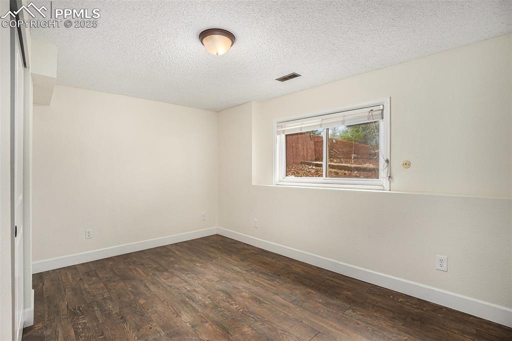 Image 26 of 31: Spare room with a textured ceiling and wood finished floors