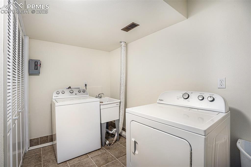 Image 27 of 31: Laundry area featuring separate washer and dryer and tile patterned floorin