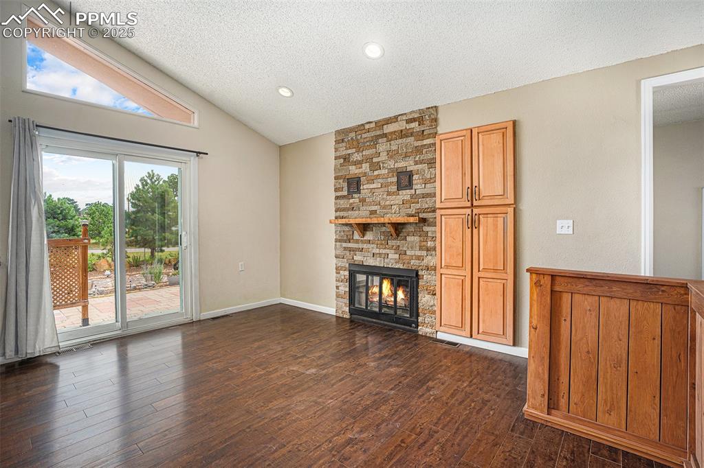 Image 5 of 31: Unfurnished dining room with a textured ceiling, dark wood-style flooring,