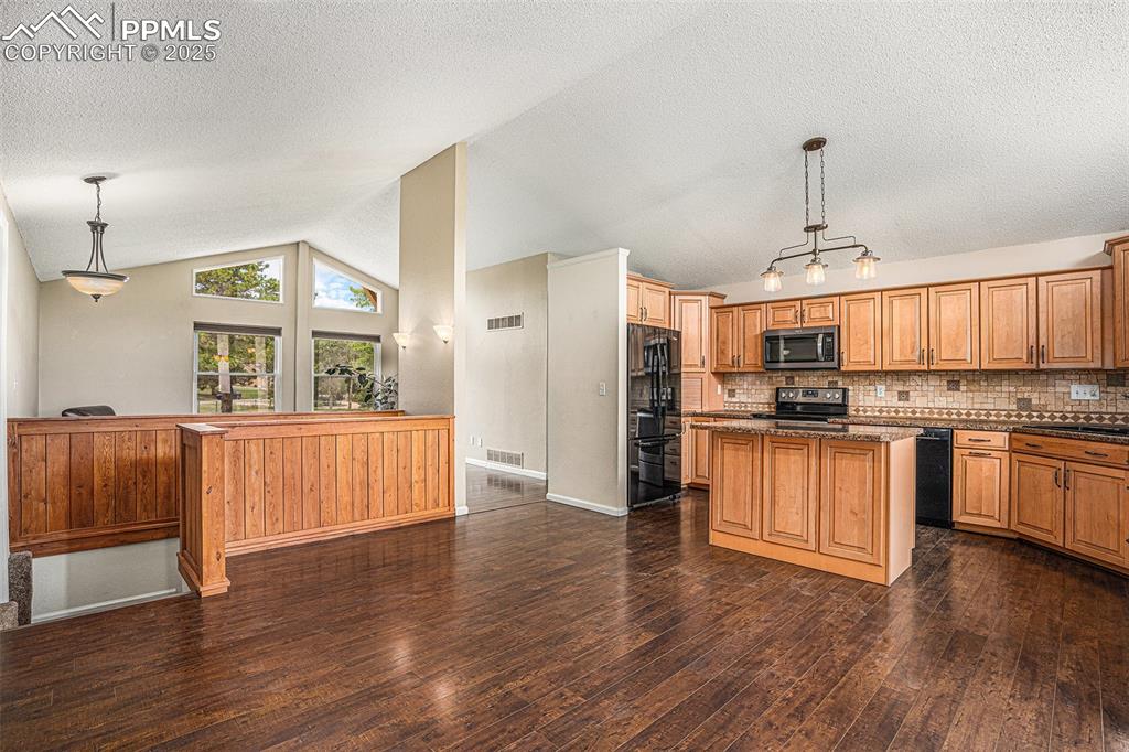 Image 6 of 31: Kitchen with vaulted ceiling, dark wood-style flooring, a textured ceiling,