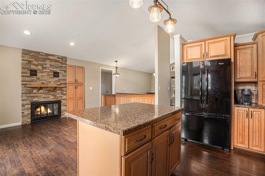 Image 9 of 31: Kitchen with freestanding refrigerator, dark wood-style floors, a textured