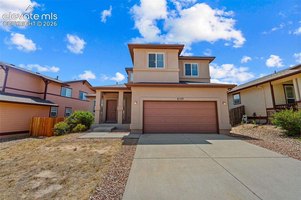 Image 1 of 33: Two-story stucco home featuring a two-car attached garage, covered front en