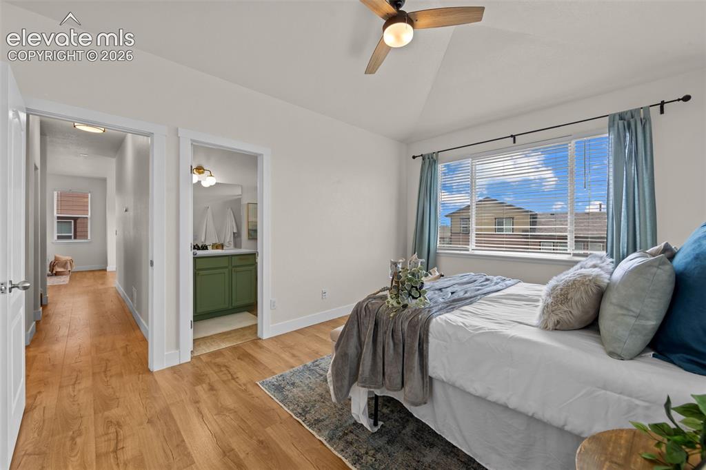 Image 10 of 33: Vaulted ceiling bedroom featuring wood-finish flooring, a ceiling fan, and 
