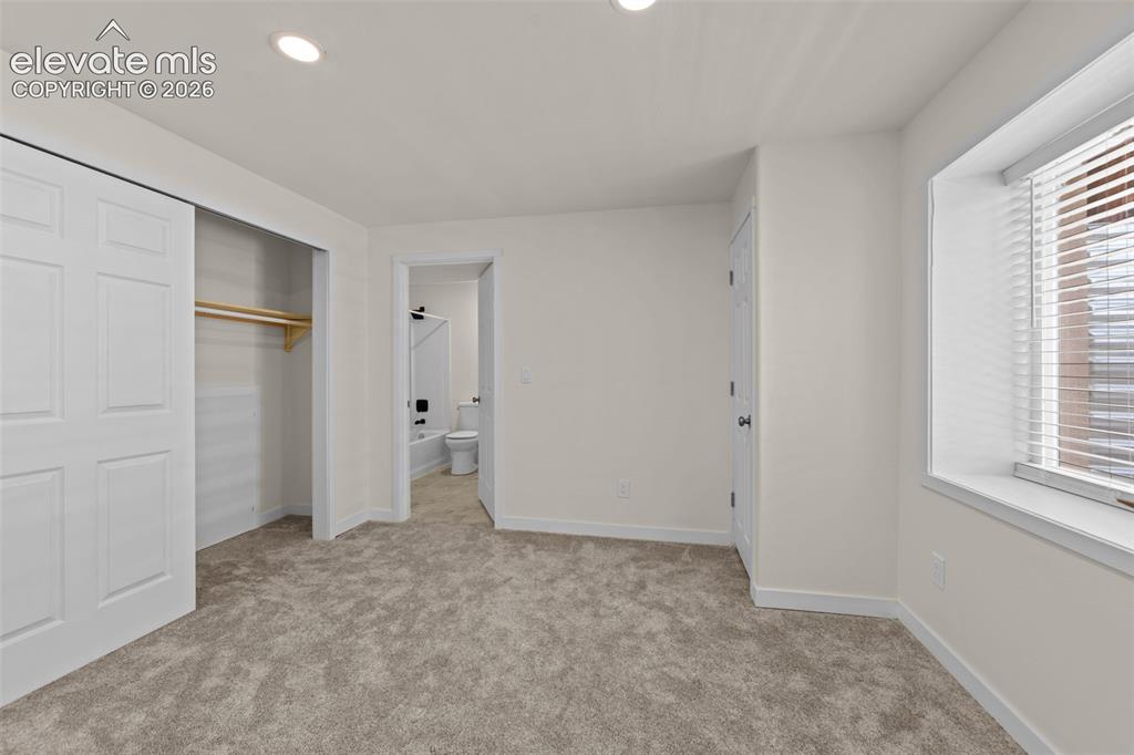 Image 26 of 33: Carpeted room featuring a window with blinds, recessed lighting, and a clos