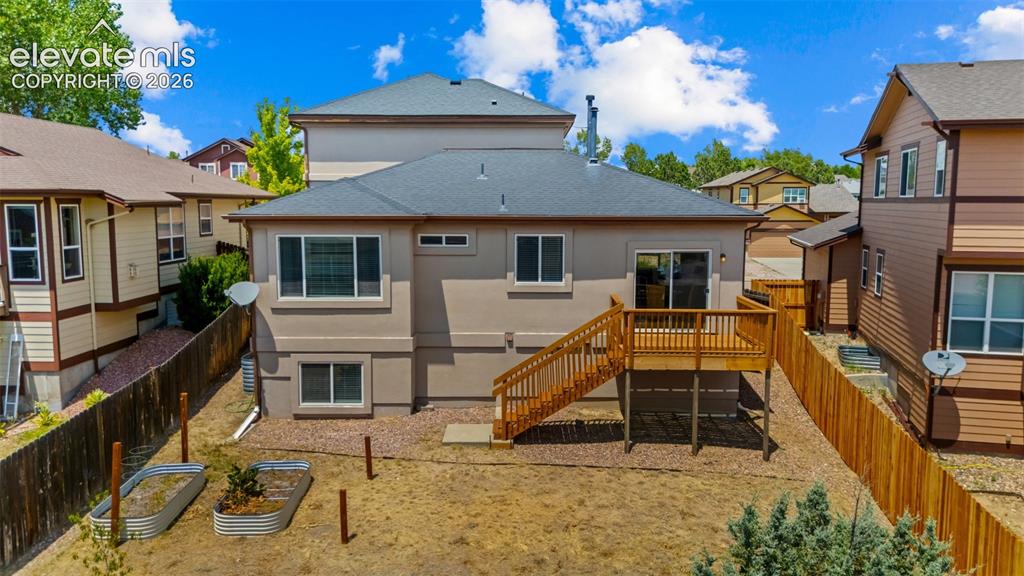Image 28 of 33: Rear exterior featuring a multi-level wood deck, ground-level patio, and a 