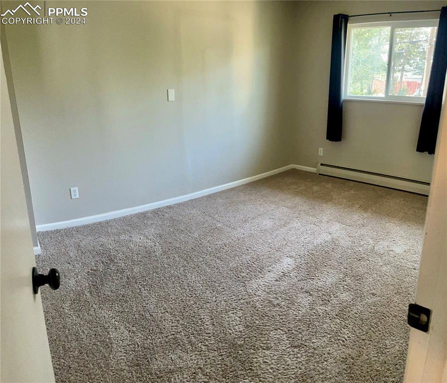 Image 24 of 47: Bedroom 2 on Main level has baseboard heating and carpet floors