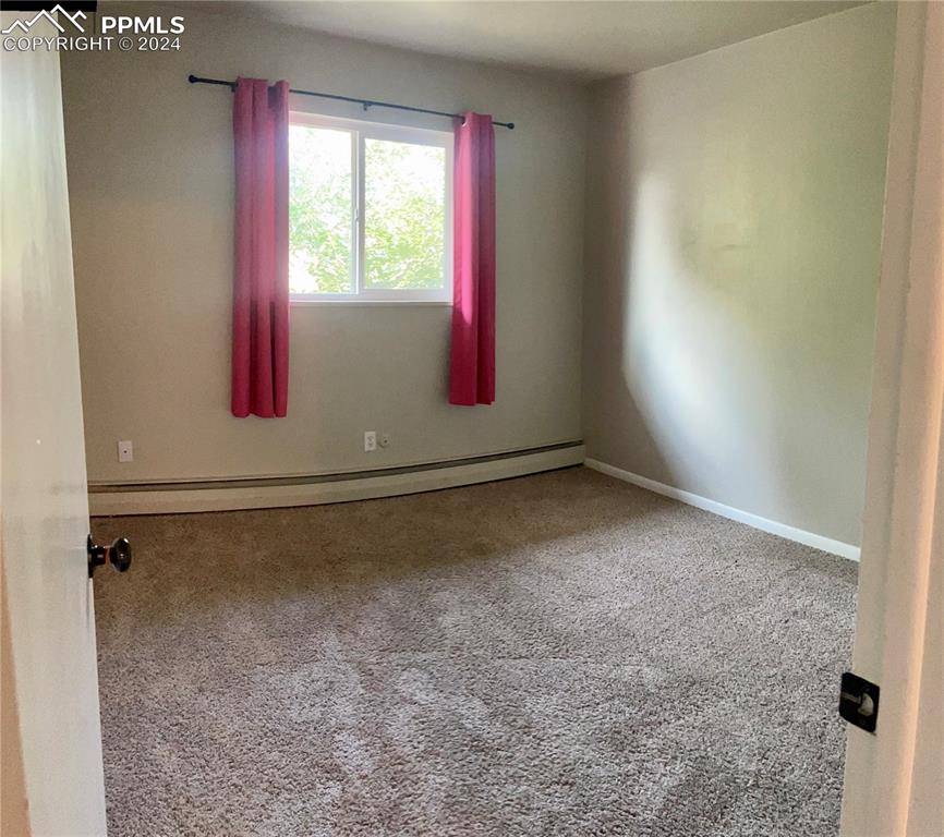 Image 25 of 47: Bedroom 3 is on the Main level. Carpeted with baseboard heating
