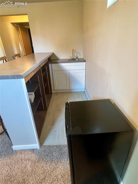 Image 30 of 47: Basement Wet bar. Mini fridge and bar stools stay.