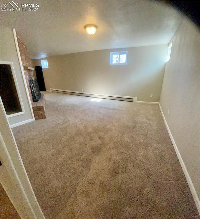 Image 31 of 47: Basement has baseboard heat, a fireplace and carpet