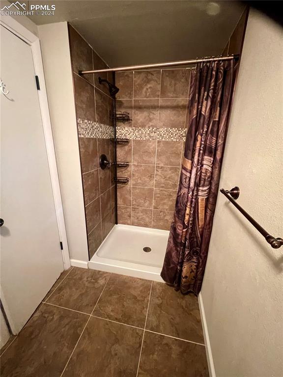 Image 34 of 47: Basement Bathroom featuring newer tile.