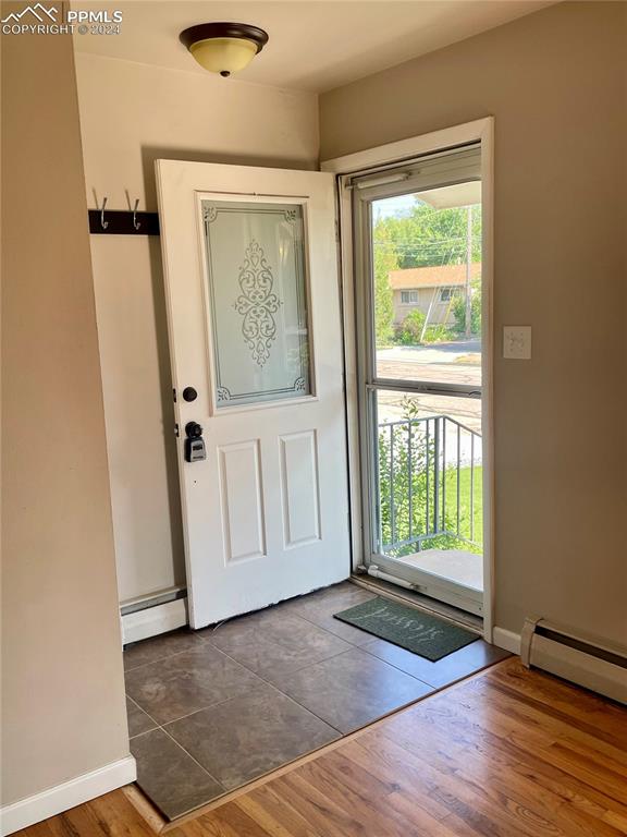 Image 4 of 47: Tile entry with hardwood floors in Great Room.