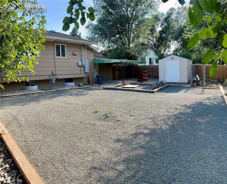 Image 40 of 47: Low maintenance back yard with lots of room for a trampoline, fire pit and/