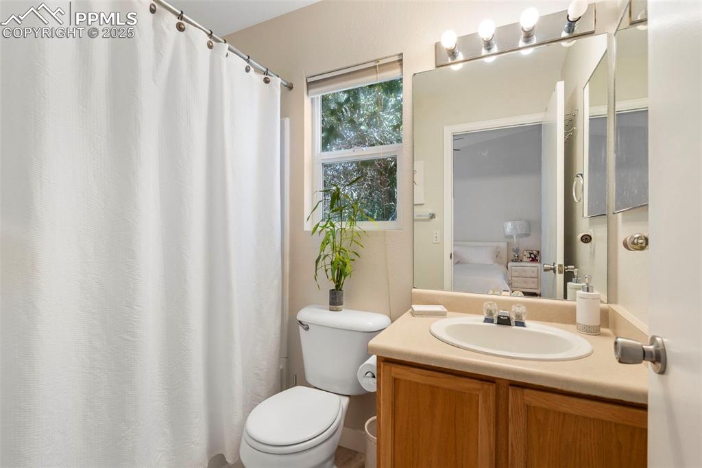 Image 17 of 25: Full bath with vanity, connected bathroom, and curtained shower